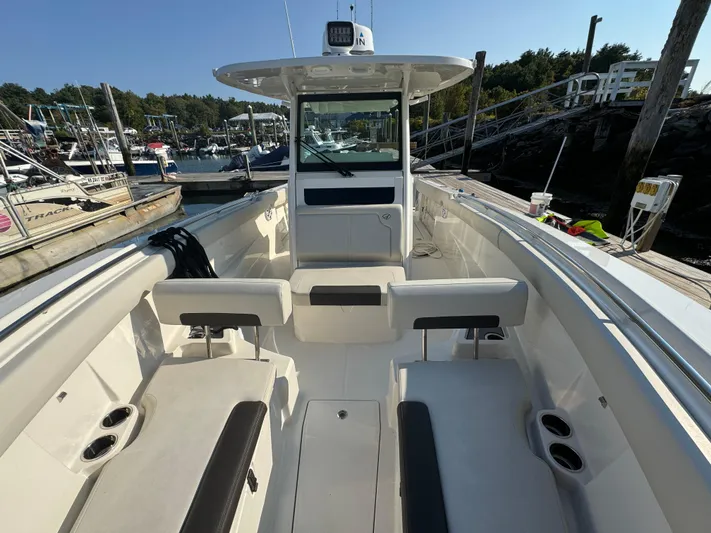 Yacht Photos Pics 2023 Sailfish 312 CC boat interior at a marina, featuring seating and cup holders.