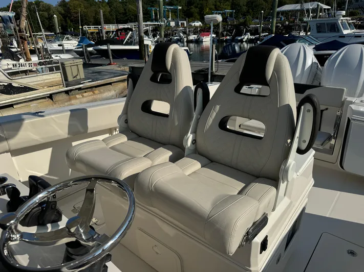  Yacht Photos Pics 2023 Sailfish 312 CC boat interior with dual seats and steering wheel at marina.