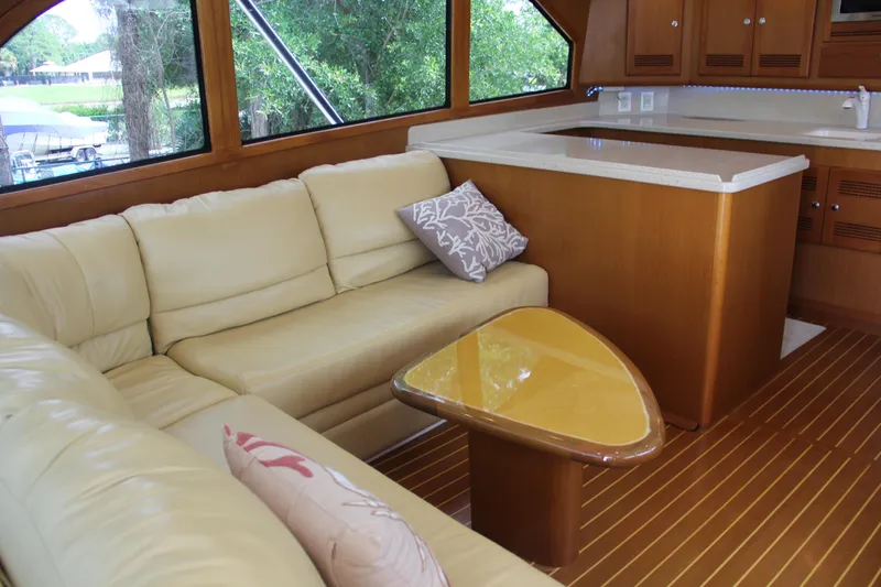  Yacht Photos Pics Luxurious interior of 2005 Cabo Flybridge CAT C18 yacht with cream sofa and wooden accents.