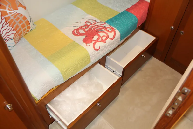  Yacht Photos Pics 2005 Cabo Flybridge CAT C18 cabin with colorful bedding and open storage drawers.