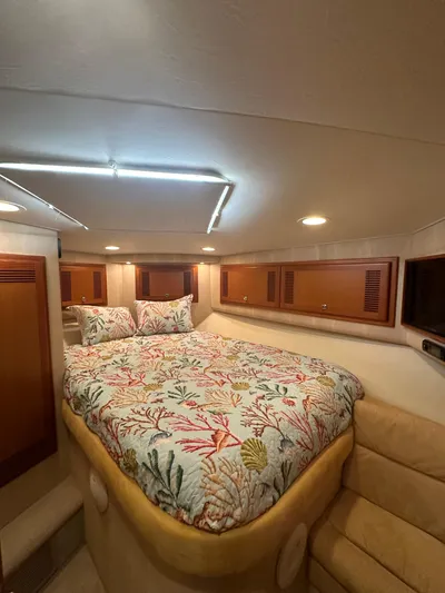  Yacht Photos Pics Luxurious 2005 Cabo Flybridge CAT C18 cabin with cozy bed and elegant wood accents.