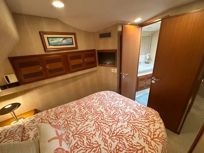  Yacht Photos Pics Luxurious cabin interior of 2005 Cabo Flybridge CAT C18 yacht with cozy bedding and wooden accents.