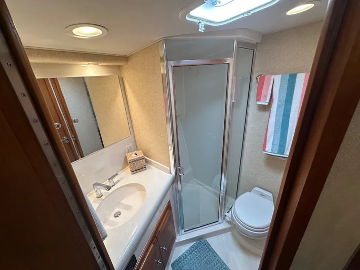  Yacht Photos Pics Bathroom interior of 2005 Cabo Flybridge CAT C18 yacht, featuring shower, sink, and toilet.