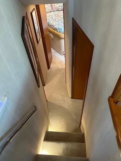  Yacht Photos Pics Stairway inside 2005 Cabo Flybridge CAT C18 yacht, featuring carpeted steps and wooden accents.
