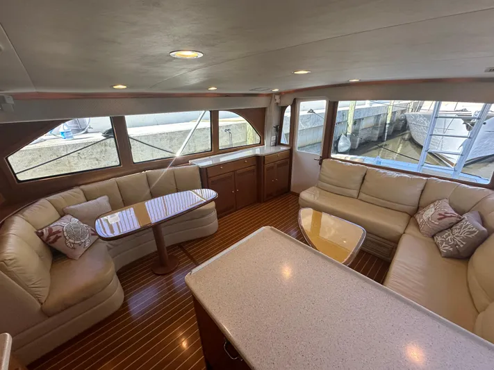  Yacht Photos Pics Luxurious interior of 2005 Cabo Flybridge CAT C18 yacht with plush seating and elegant wood finishes.