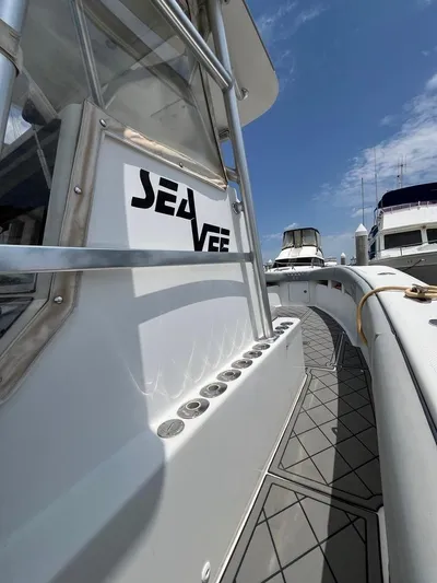 Albie Fishing Yacht Photos Pics 2007 SeaVee 34B boat deck with logo, docked under a clear blue sky.