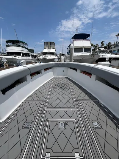 Albie Fishing Yacht Photos Pics 2007 SeaVee 34B boat deck with patterned flooring, docked among other boats under a blue sky.