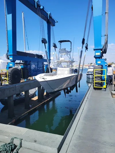 Albie Fishing Yacht Photos Pics 2007 SeaVee 34B boat being lifted by a blue crane at a marina.
