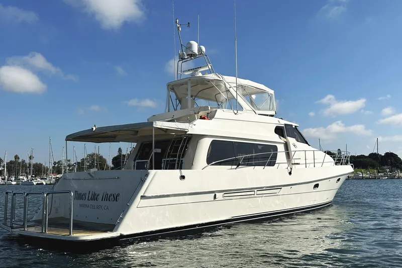 Times Like These Yacht Photos Pics 2004 McKinna 57 PHMY Widebody yacht with stabilization, docked in a marina under blue skies.