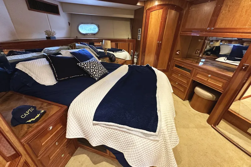 Times Like These Yacht Photos Pics Luxurious 2004 McKinna 57 PHMY yacht bedroom with elegant wood finishes and cozy bedding.