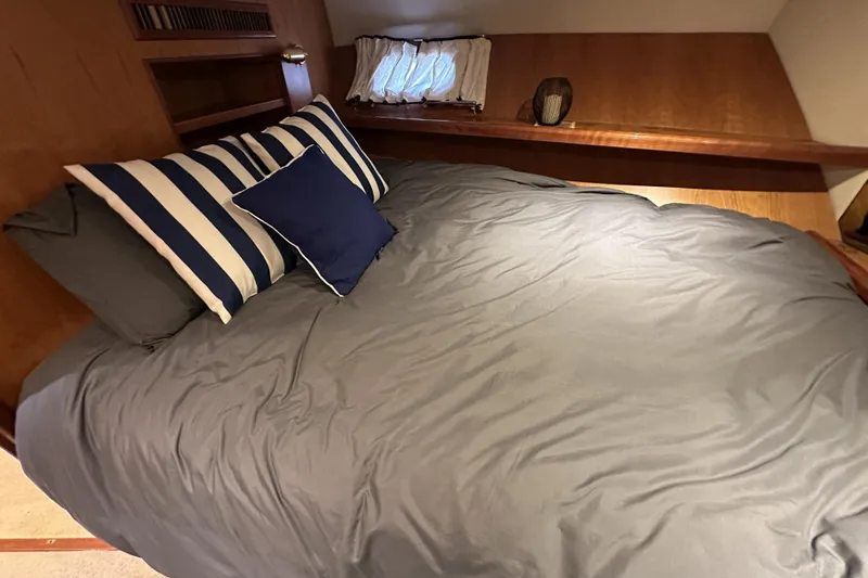 Times Like These Yacht Photos Pics Cozy bedroom in 2004 McKinna 57 PHMY yacht with striped pillows and wooden accents.
