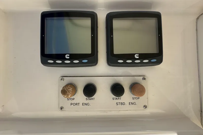 Times Like These Yacht Photos Pics Control panel of a 2004 McKinna 57 PHMY Widebody yacht with dual screens and engine buttons.