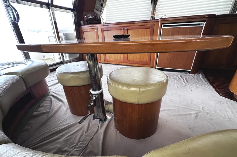 Times Like These Yacht Photos Pics Interior of 2004 McKinna 57 PHMY yacht with wooden table and cushioned seating.