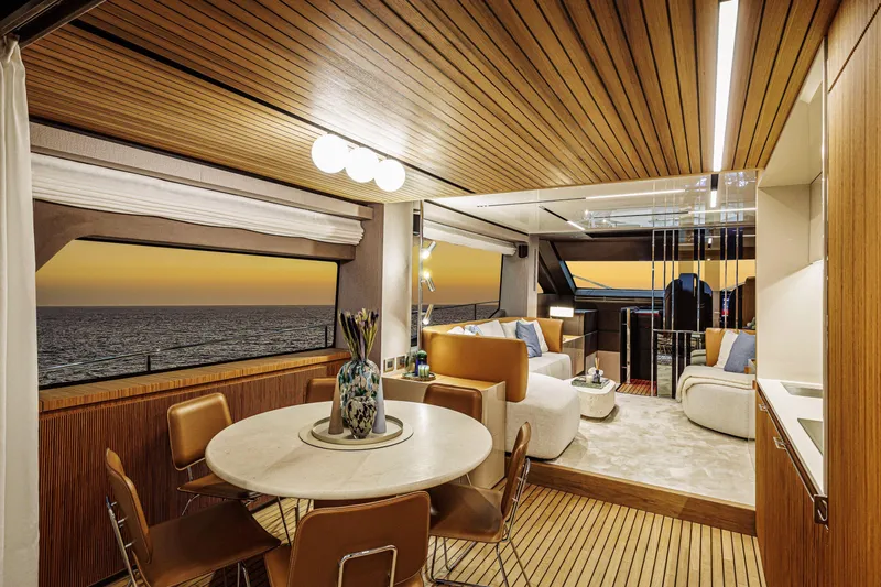  Yacht Photos Pics Luxurious interior of 2026 Cranchi Sessantadue 62 yacht at sunset, featuring elegant seating and dining area.