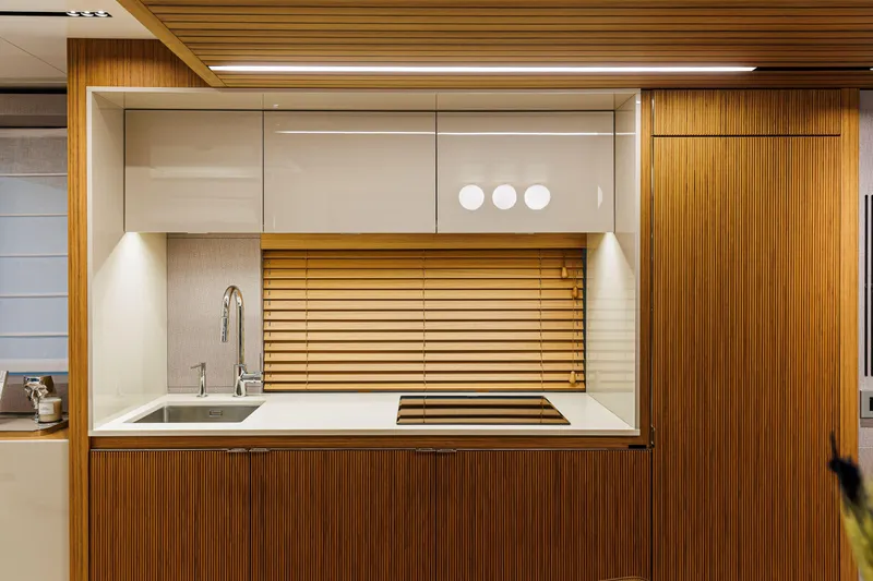  Yacht Photos Pics Modern kitchen interior on 2026 Cranchi Sessantadue 62 yacht, featuring sleek wood finishes.