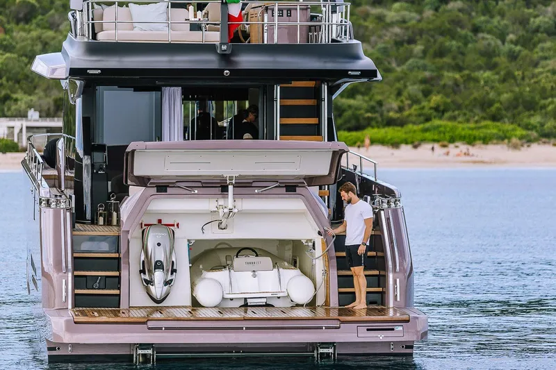  Yacht Photos Pics 2026 Cranchi Sessantadue 62 yacht with open garage and man on deck.