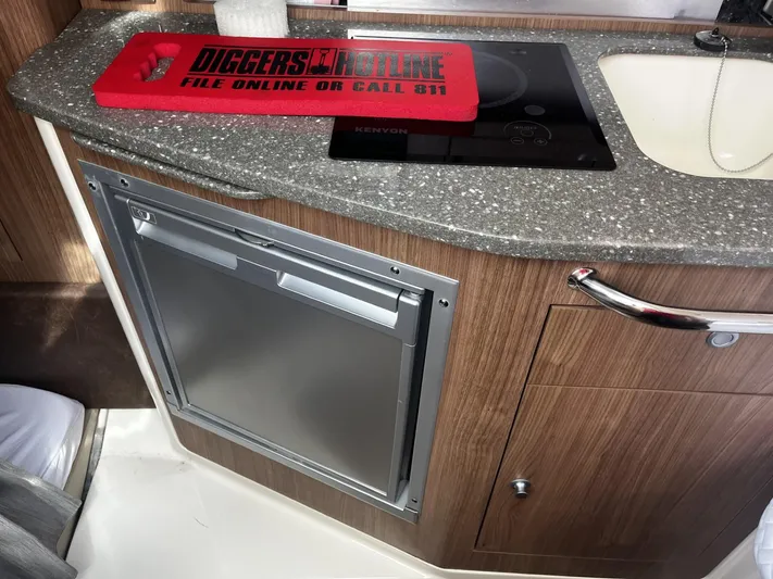  Yacht Photos Pics 2017 Boston Whaler 315 Conquest interior with kitchenette, featuring a stove, sink, and storage.