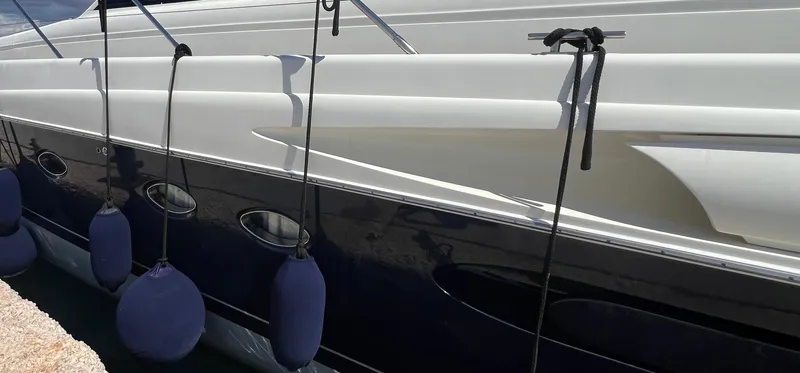 1691 Yacht Photos Pics Side view of a 2000 Princess V65 yacht with blue fenders attached.