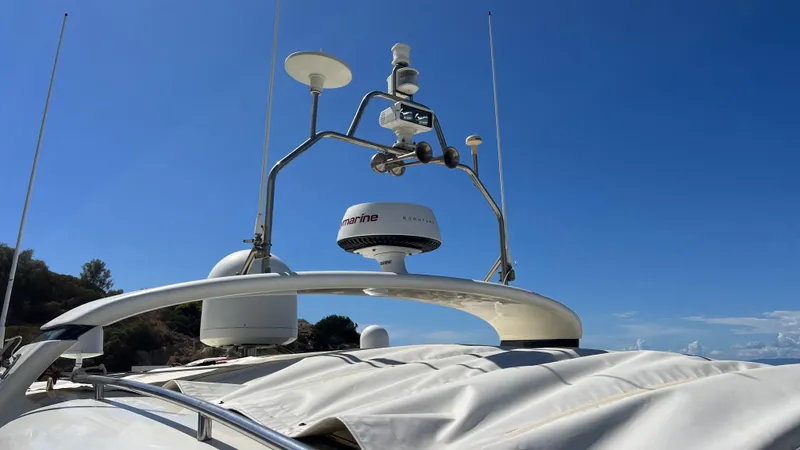 1691 Yacht Photos Pics Top view of a 2000 Princess V65 yacht with radar and antennas against a clear blue sky.