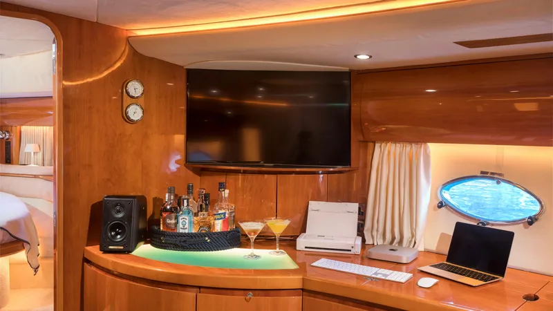 1691 Yacht Photos Pics Luxurious interior of 2000 Princess V65 yacht with bar, TV, and workspace.