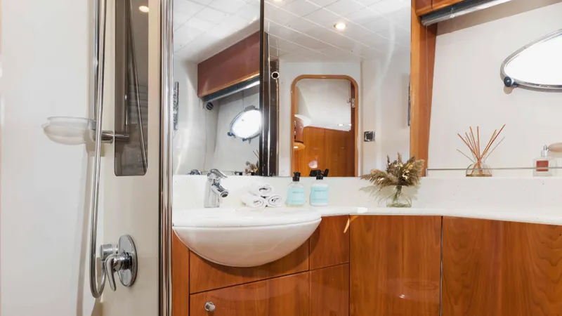 1691 Yacht Photos Pics Luxurious bathroom interior on 2000 Princess V65 yacht with wooden cabinetry and modern fixtures.