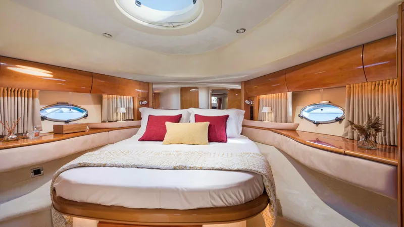 1691 Yacht Photos Pics Luxurious cabin interior of a 2000 Princess V65 yacht with elegant bedding and porthole windows.