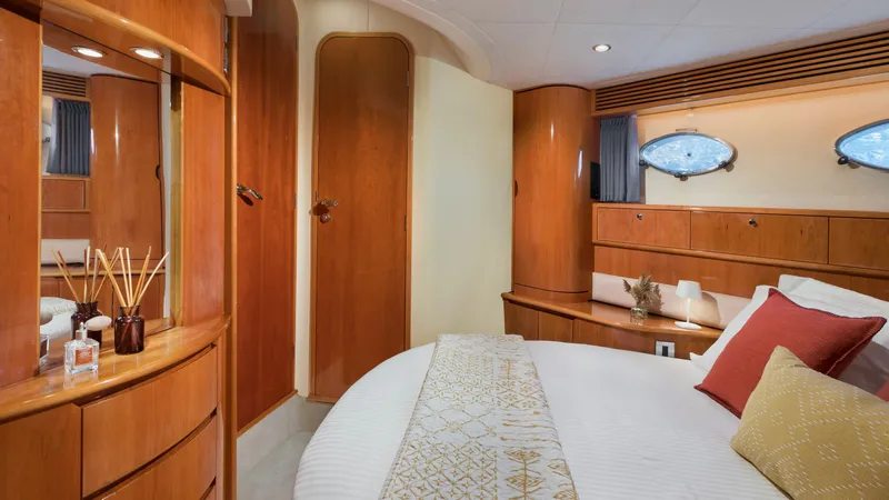 1691 Yacht Photos Pics Luxurious cabin interior of 2000 Princess V65 yacht with elegant wood finishes and cozy bedding.