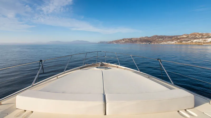 1691 Yacht Photos Pics Bow view of 2000 Princess V65 yacht cruising on calm sea near coastline.