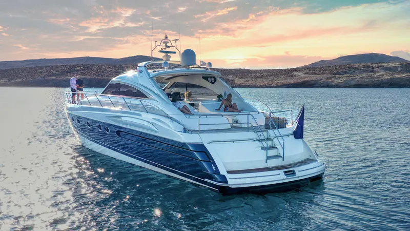 1691 Yacht Photos Pics Luxurious 2000 Princess V65 yacht cruising on serene waters at sunset.