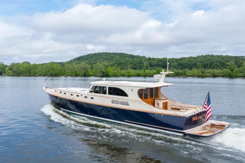 Dreadnought Yacht Photos Pics 2007 Vicem 65 yacht cruising on a serene lake with lush green hills.