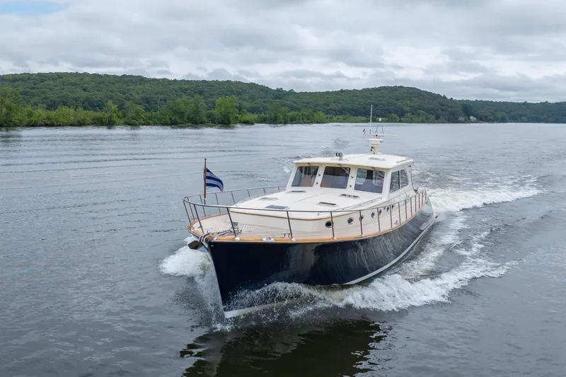 Dreadnought Yacht Photos Pics 2007 Vicem 65 yacht cruising on a scenic river with lush green hills.