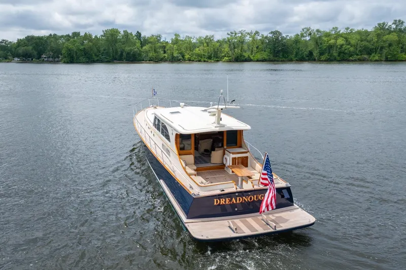 Dreadnought Yacht Photos Pics 2007 Vicem 65 yacht cruising on a serene lake with lush green shoreline.