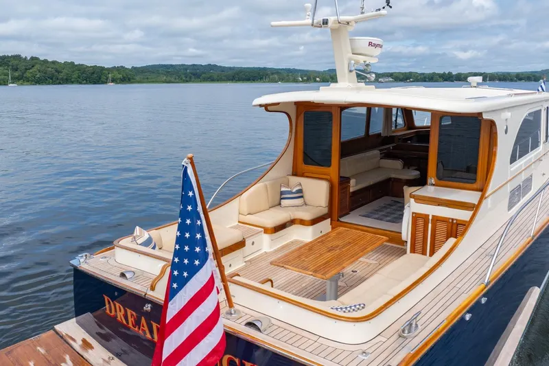 Dreadnought Yacht Photos Pics 2007 Vicem 65 yacht with American flag, featuring elegant wood and spacious seating.