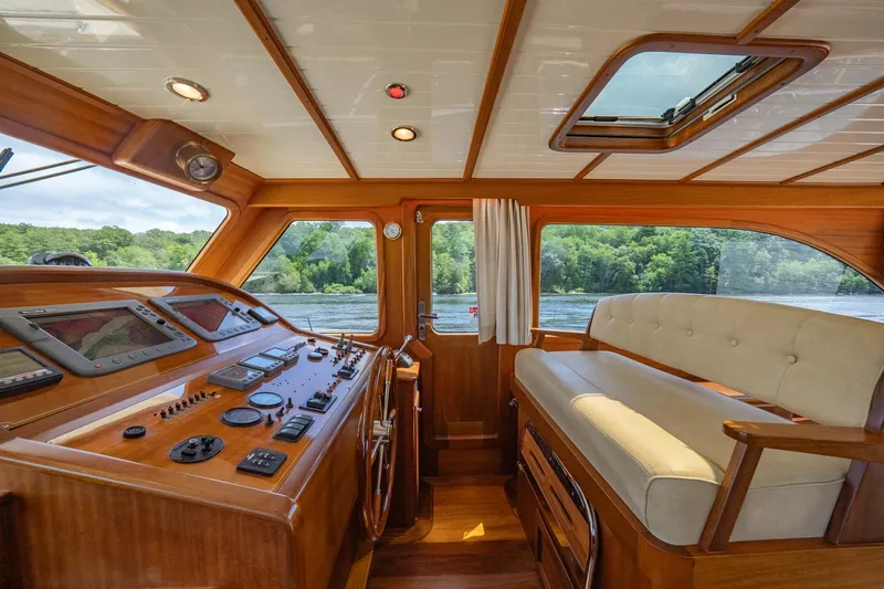Dreadnought Yacht Photos Pics Luxurious 2007 Vicem 65 yacht interior with wooden helm and plush seating.