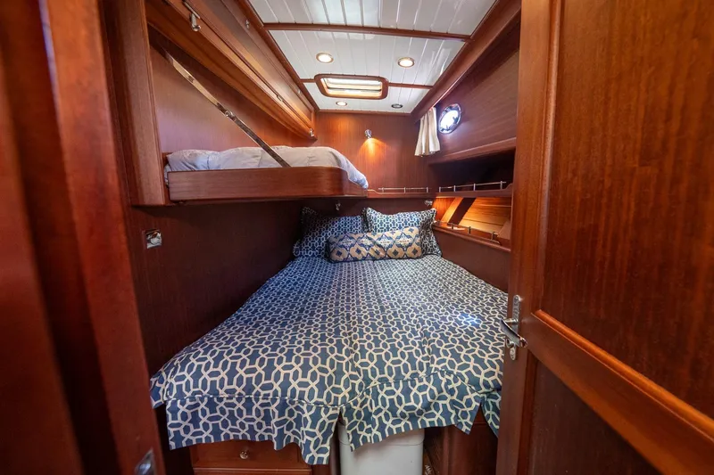 Dreadnought Yacht Photos Pics Luxurious cabin interior of 2007 Vicem 65 yacht with wooden finish and cozy bedding.