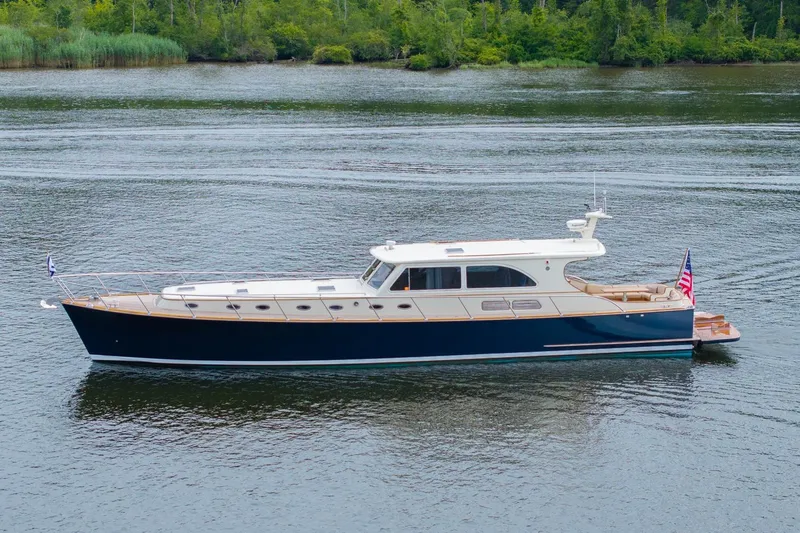 Dreadnought Yacht Photos Pics 2007 Vicem 65 yacht on calm water with lush green shoreline.