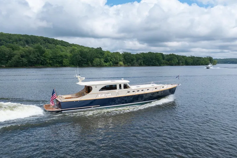 Dreadnought Yacht Photos Pics 2007 Vicem 65 yacht cruising on a scenic river with lush green forest backdrop.
