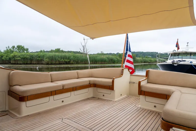 Dreadnought Yacht Photos Pics Luxurious 2007 Vicem 65 yacht deck with comfortable seating and scenic river view.