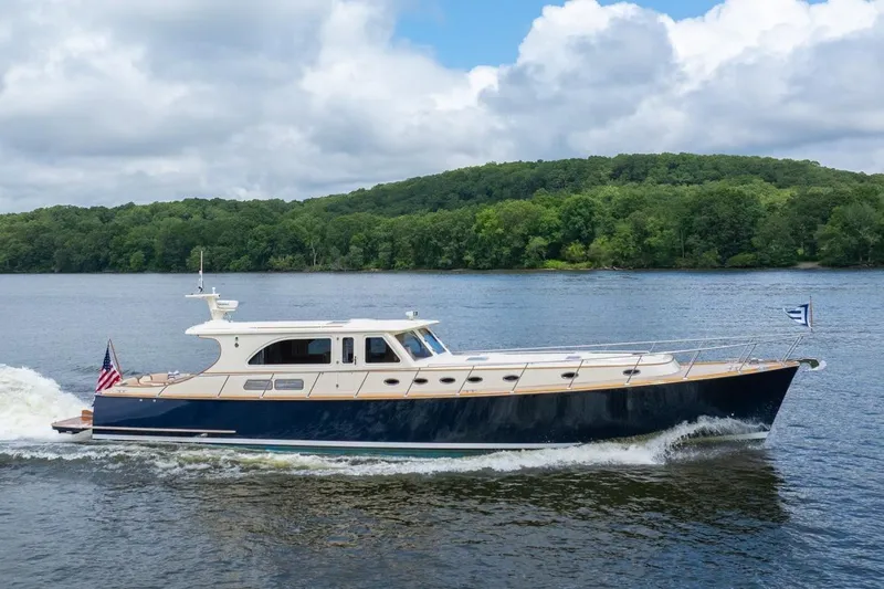 Dreadnought Yacht Photos Pics 2007 Vicem 65 yacht cruising on a scenic river with lush green forest backdrop.