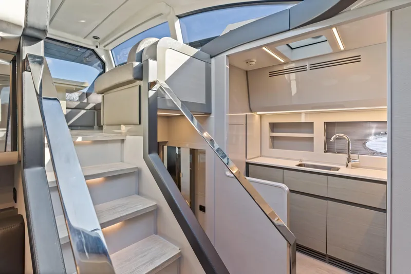  Yacht Photos Pics Luxurious interior of 2016 Pershing 62' yacht with modern kitchen and sleek staircase.