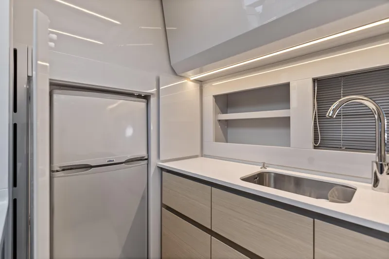  Yacht Photos Pics Modern kitchen interior of 2016 Pershing 62' yacht with sleek cabinetry and stainless steel sink.