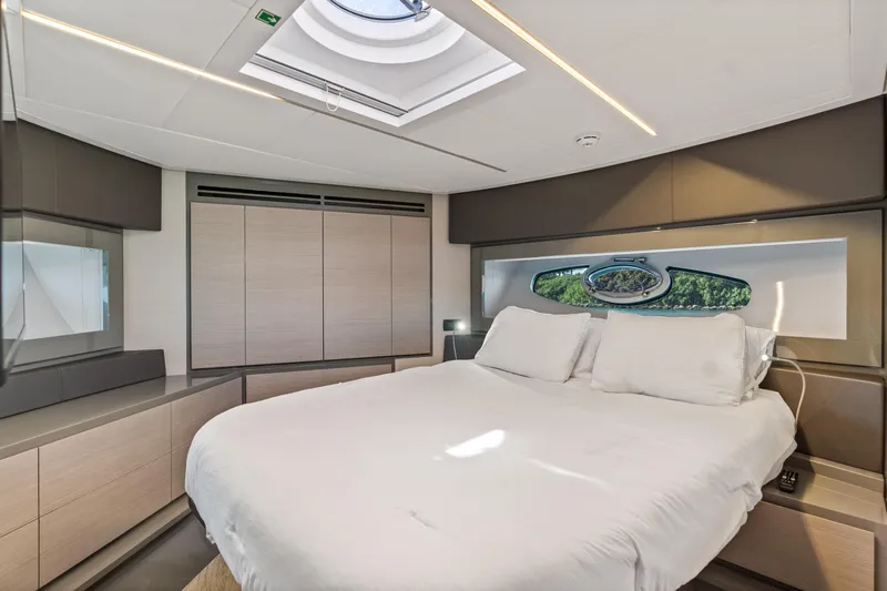  Yacht Photos Pics Luxurious bedroom interior of 2016 Pershing 62' yacht with skylight and modern design.