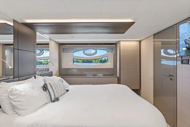  Yacht Photos Pics Luxurious bedroom interior of 2016 Pershing 62' yacht with modern design and window view.
