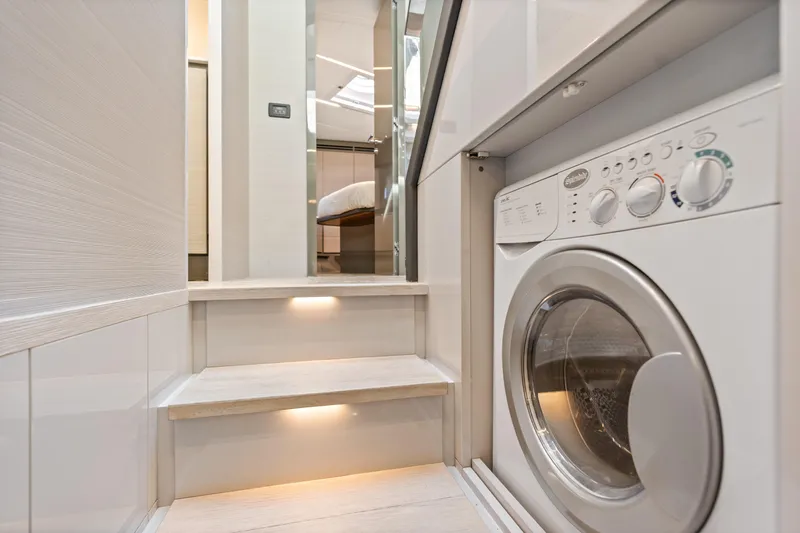  Yacht Photos Pics Laundry area in 2016 Pershing 62' yacht with modern washer and illuminated steps.