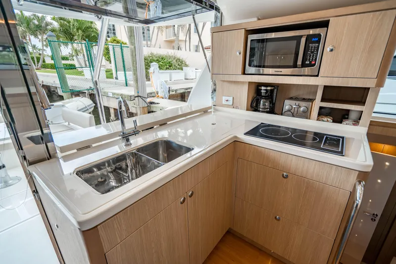 Altair Yacht Photos Pics Modern kitchen in 2019 Aquila 44 Yacht with sink, stove, and microwave.