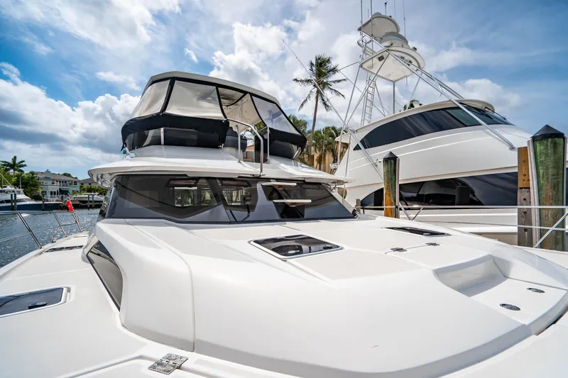 Altair Yacht Photos Pics 2019 Aquila 44 Yacht docked under a sunny sky with palm trees.