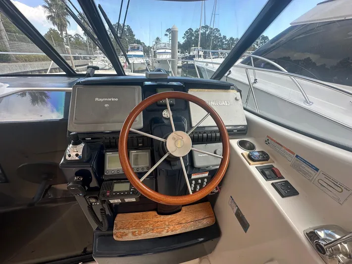 Five Too Soon Yacht Photos Pics 2008 Tiara Yachts 3500 Sovran helm with wooden steering wheel and navigation equipment.