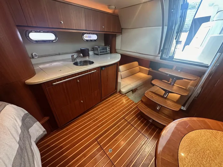 Five Too Soon Yacht Photos Pics 2008 Tiara Yachts 3500 Sovran interior with wooden flooring and compact kitchen area.