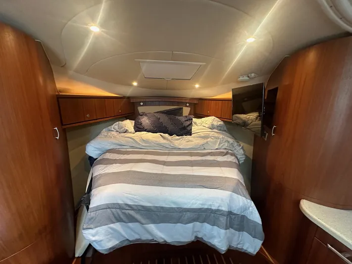 Five Too Soon Yacht Photos Pics 2008 Tiara Yachts 3500 Sovran cabin with cozy bed and wooden interior.