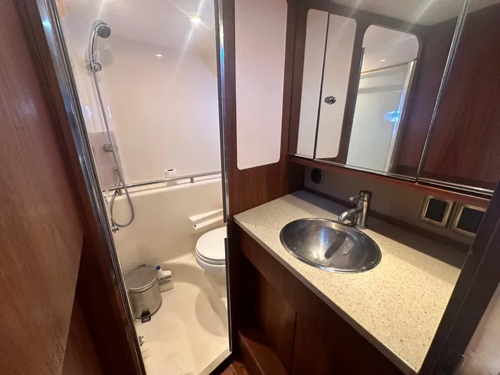 Five Too Soon Yacht Photos Pics 2008 Tiara Yachts 3500 Sovran bathroom with shower, sink, and wooden cabinetry.